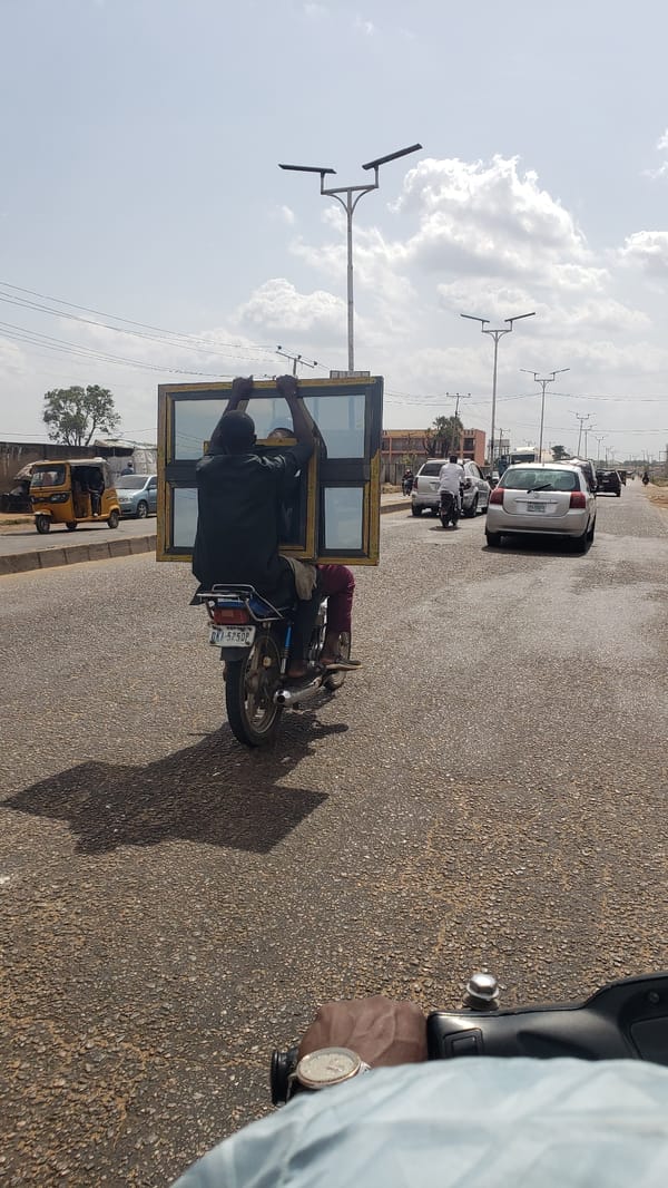 Motorcyclist carries large window frame on Nigerian road