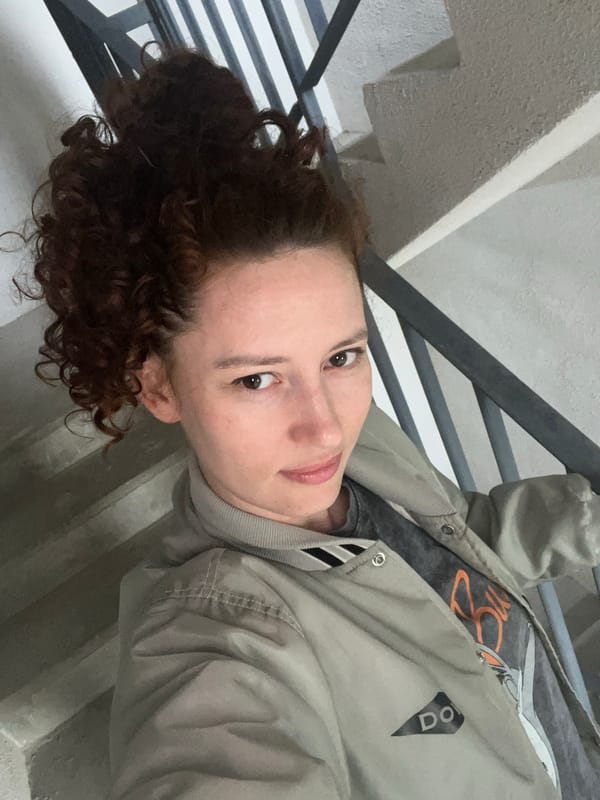Person in bomber jacket sits on steps in Saint Petersburg