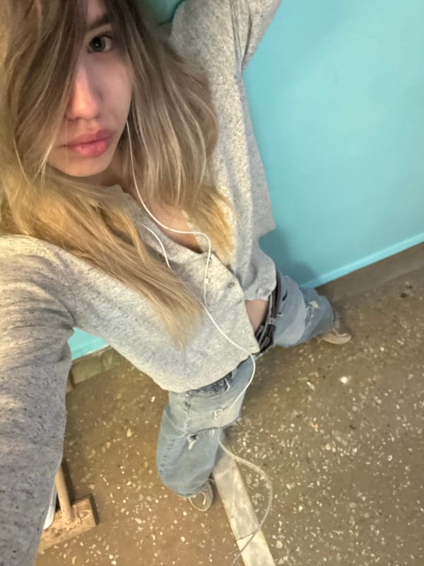 Woman rests on bench with headphones in Noviy, Russia