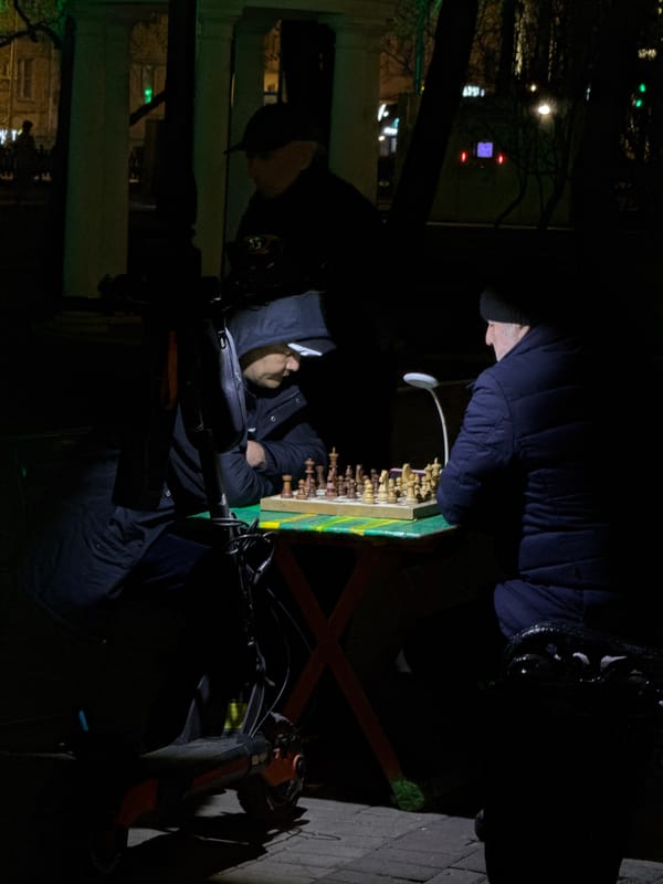 Nighttime chess match observed in Moscow street setting