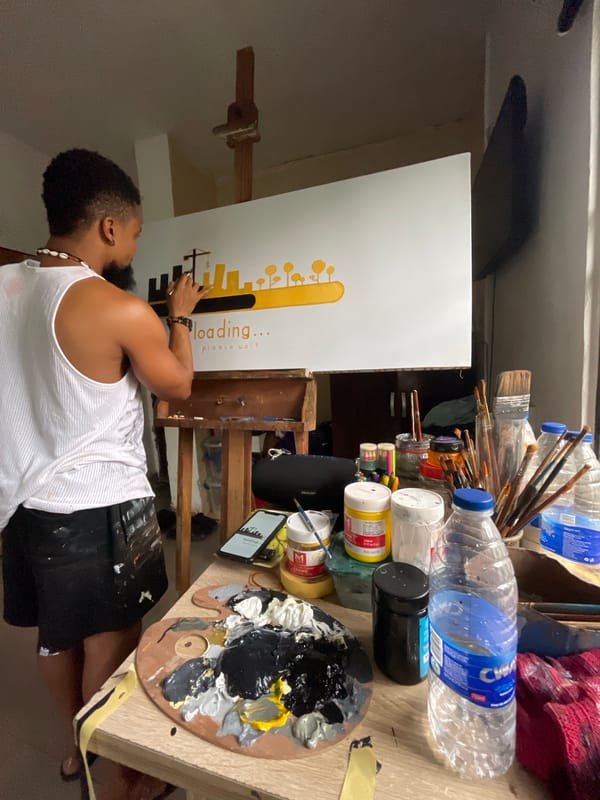 Artist paints "loading" cityscape canvas in Ado studio