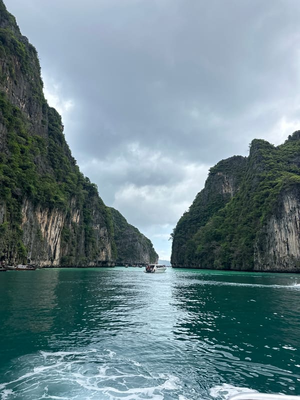 Limestone bay in Haad Yao with longtail boats and clear turquoise water