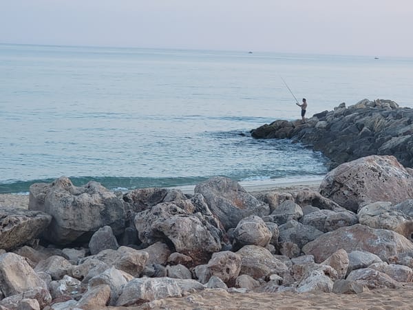 Quarteira beach at golden hour: fishing, moonrise, and calm seas