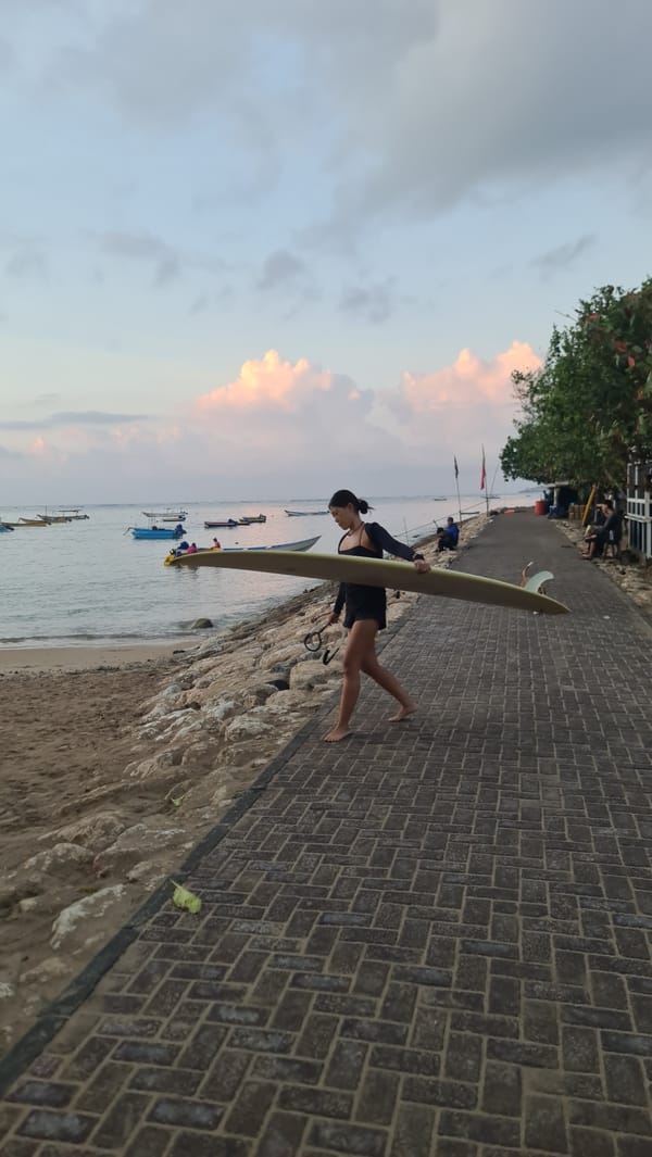Denpasar's coastline at sunset: surf, boats, and shoreline life