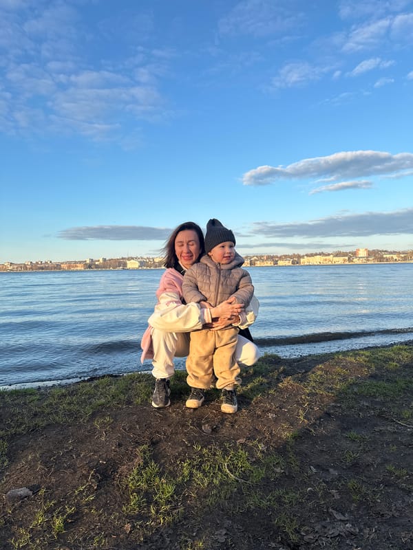 Woman, child rest together by waterside in Votkinsk