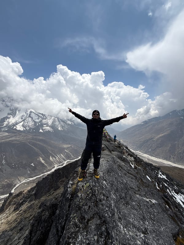 Hiker poses at prayer flag viewpoint in Nepal mountains