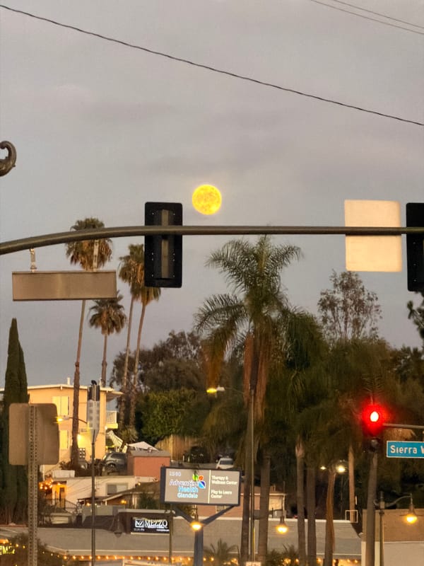 Big moon rises over LA streets at dusk