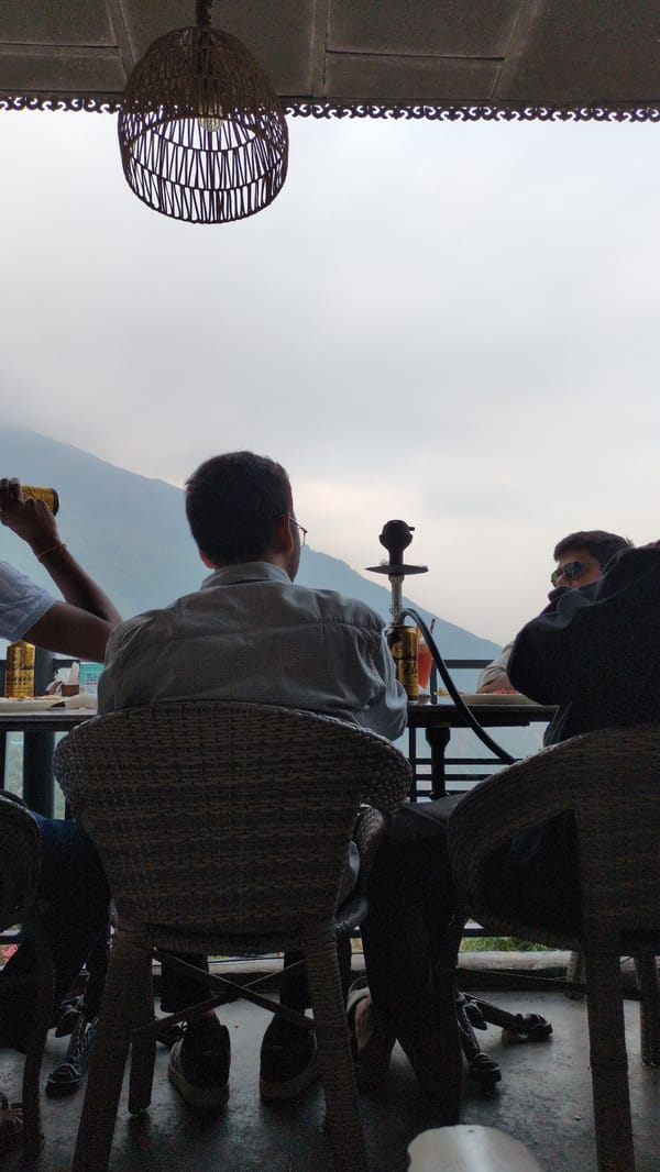 Friends share casual lunch and hookah in Dharamkot cafe