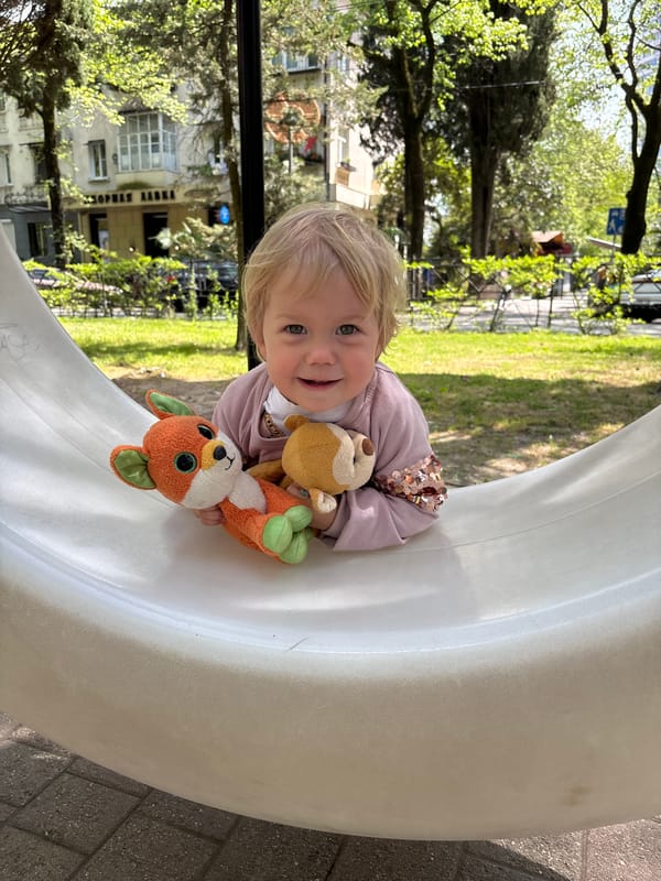 Child plays with stuffed animals in white structure, Sochi