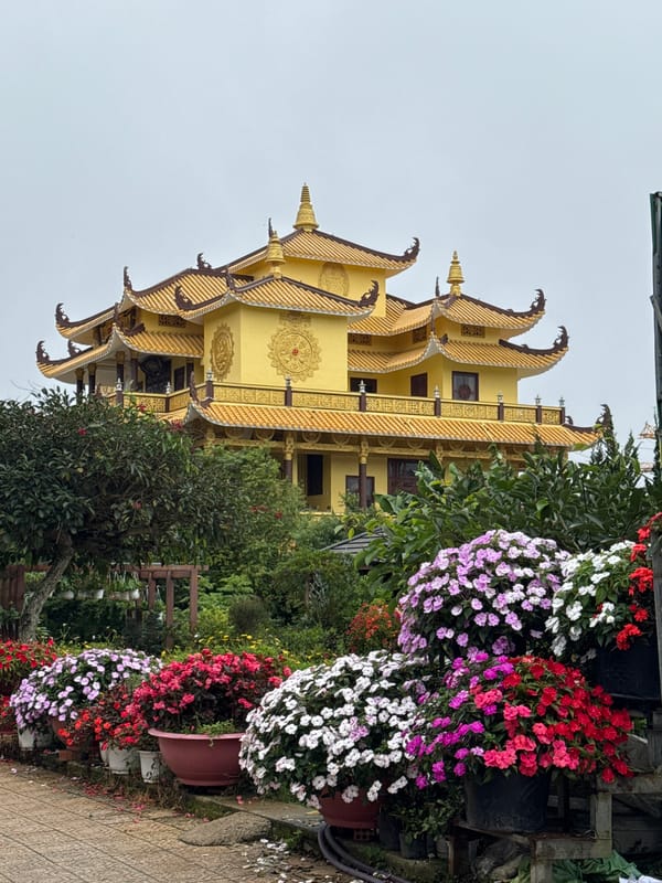 Ornate Buddhist temple and flower-lined walkway in Da Lat