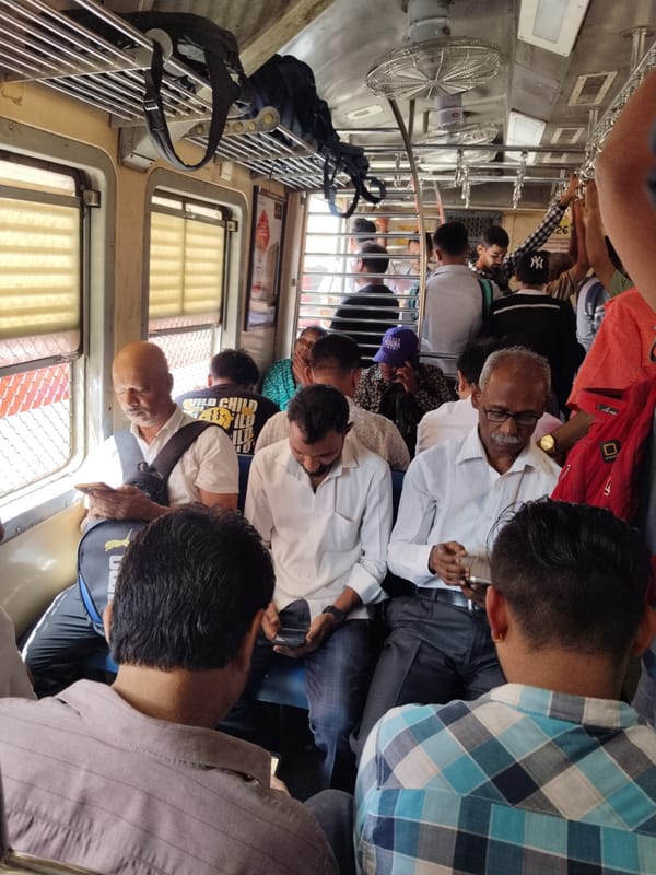 Mumbai commuters use phones on crowded morning train
