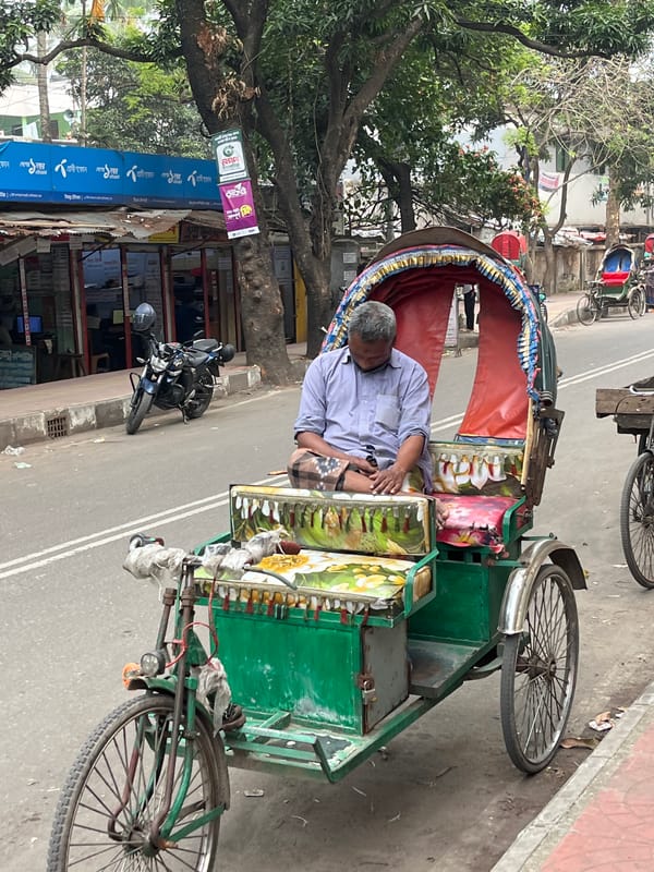 Man sleeps in decorated rickshaw on Dhaka street