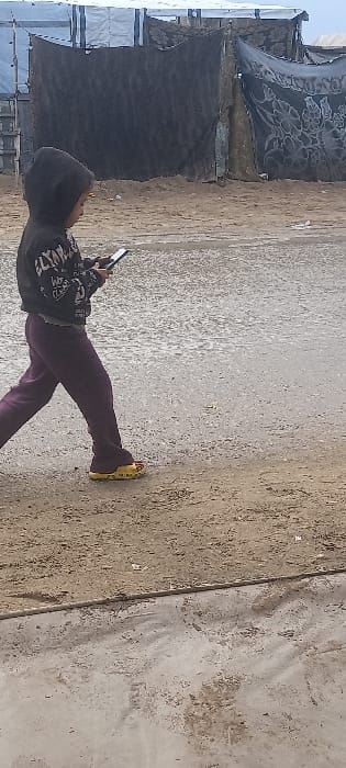 Residents navigate muddy streets in Khan Yunis camp