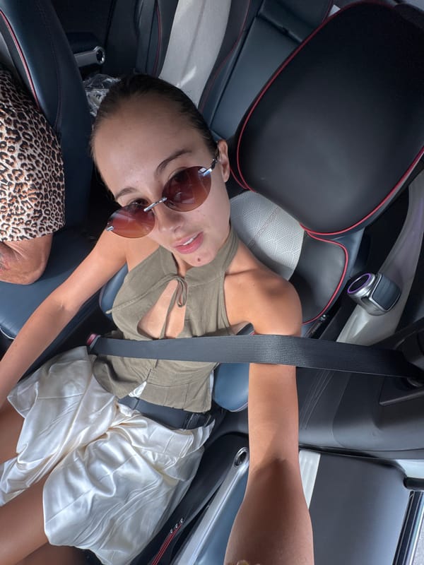 Woman in sunglasses relaxes in car in Khok Kloi
