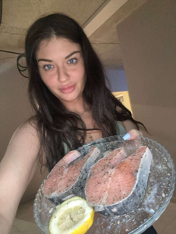 Woman prepares seasoned salmon steaks in Khimki apartment