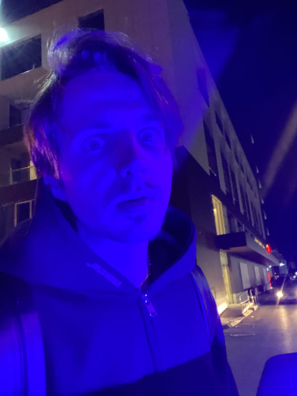 Man photographed in blue lighting displays surprised expression in Bar