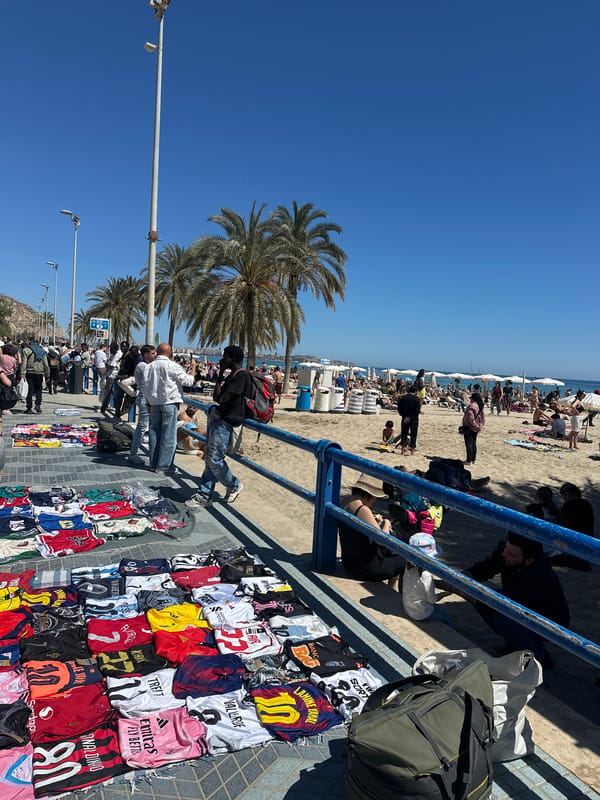Street vendors sell merchandise on busy Alicante promenade