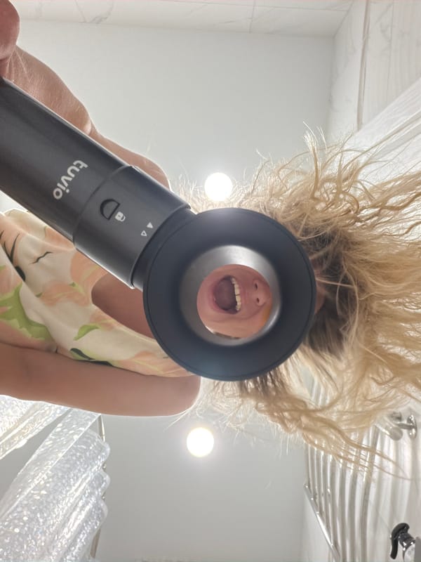 Hair drying routine in a Votkinsk bathroom, floral dress and eye patches