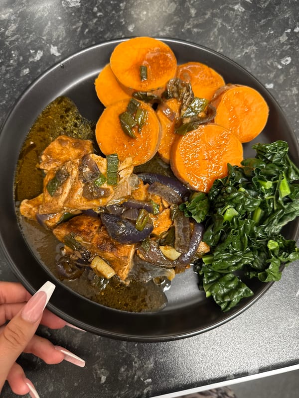 Sweet potato rounds in savory sauce on a black plate