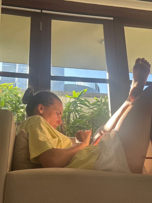 Woman relaxes on sofa with feet up in Pecatu