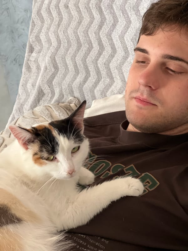 Family relaxes at home with cat in Rossiyskiy
