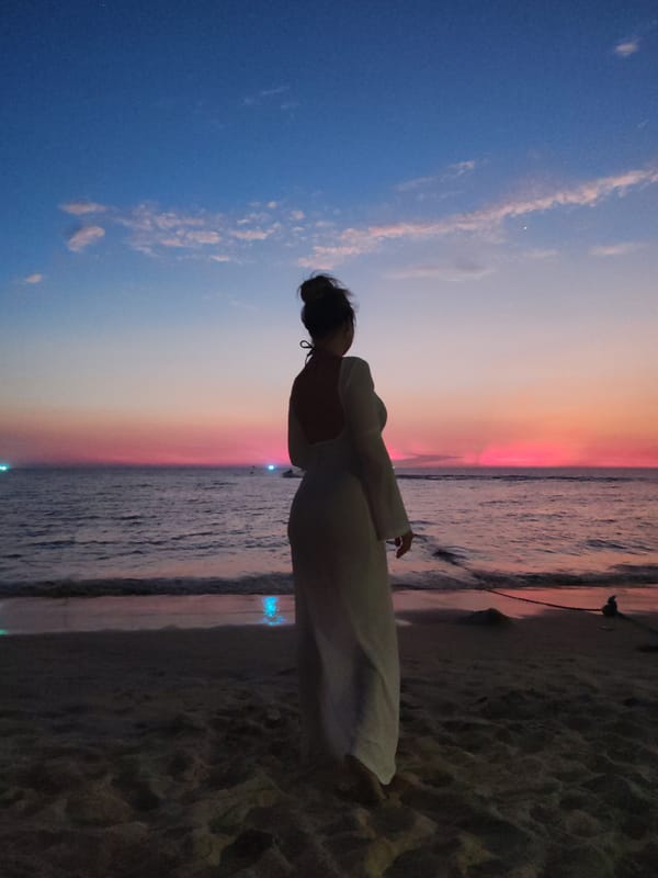 Woman in white dress watches sunset on Karon beach
