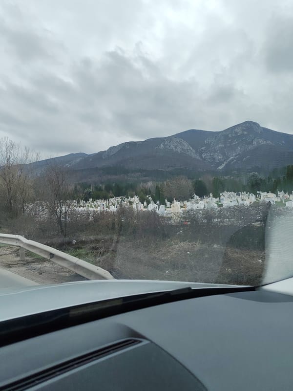 Vehicle drives past cemetery and wet roads in Vratsa
