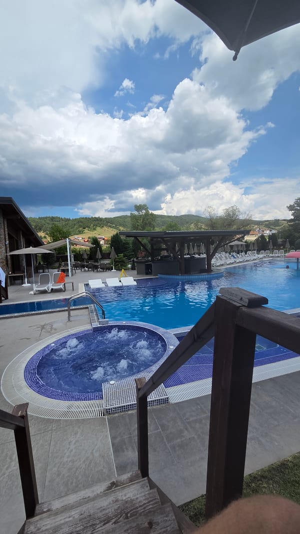 Pool and jacuzzi facility documented under cloudy afternoon skies