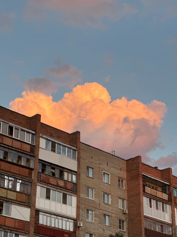 Brick apartment block against a peachy sunset sky in Omsk
