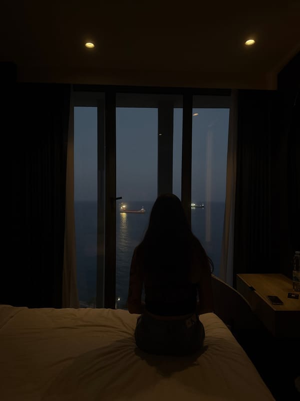 Dimly lit Limassol hotel room with Mediterranean sea view at dusk