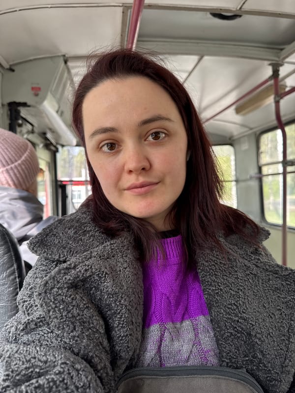 Woman in gray fleece rides bus through Izhevsk