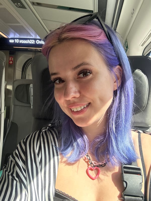 Woman with colorful hair photographed smiling on Spanish train