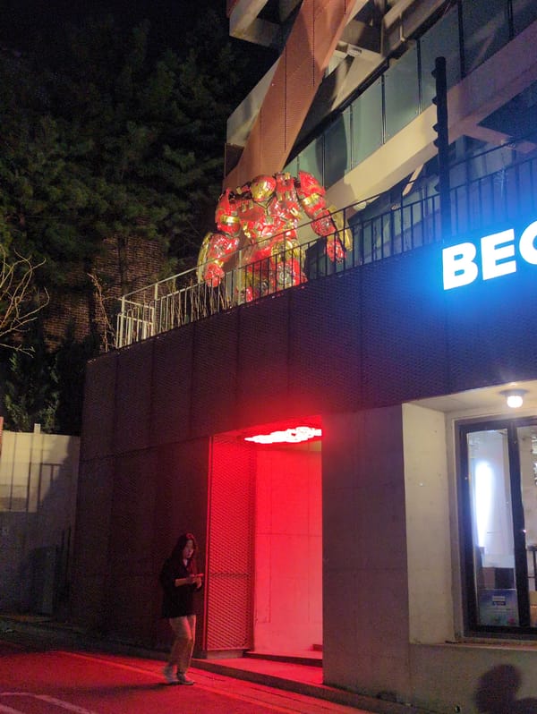 Woman with phone spotted under illuminated Seoul building signage