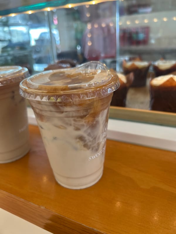 Cafe visit documented through coffee, pastries, art supplies