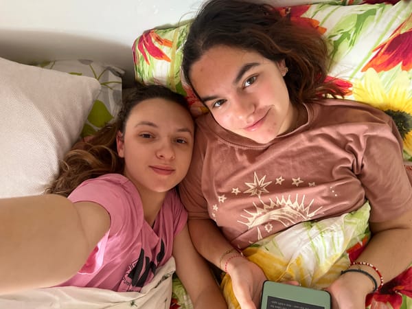 Two women relax on bed with phone in Saarbrücken