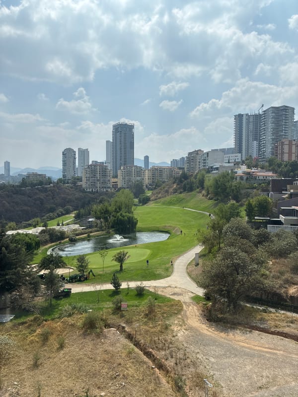 Person smoking at elevated viewpoint overlooking Huixquilucan golf course
