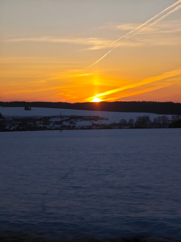 Sunset illuminates snow-covered field near Большая Уса, Russia