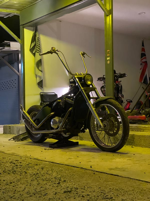 Black motorcycle parked in garage with British flag backdrop
