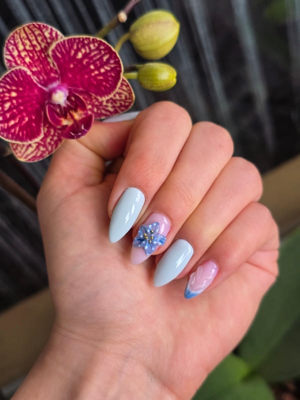 Woman displays decorated nail art with orchid in Burgas