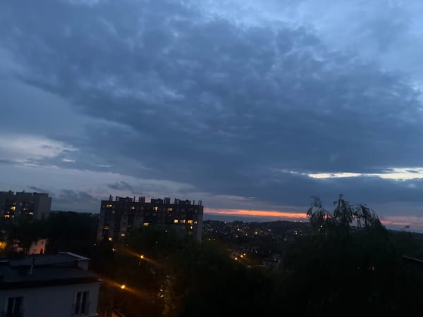 City skyline at dusk, lights coming on across the neighborhood