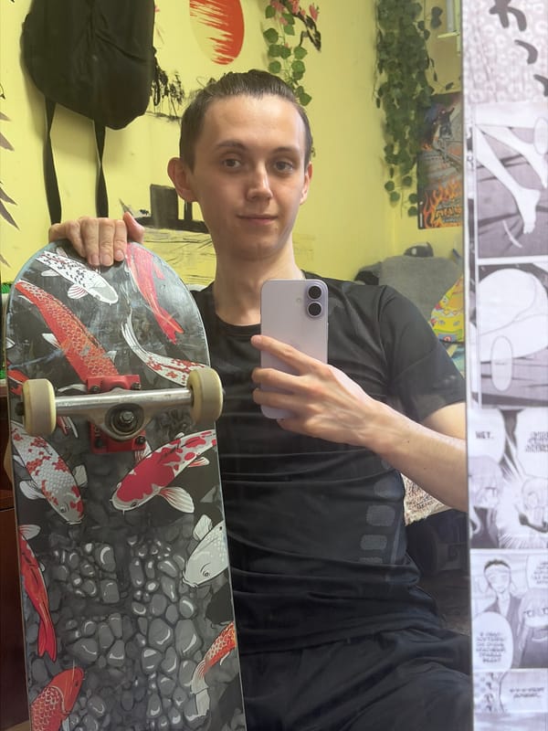 Koi fish skateboard and black Vans, indoors