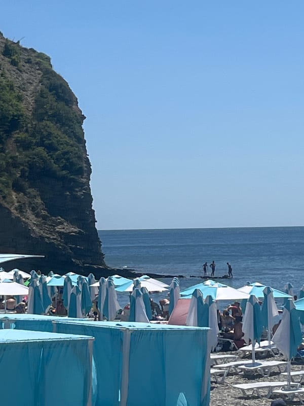 Sunny beach day with umbrellas, lounge chairs, and lifeguard post