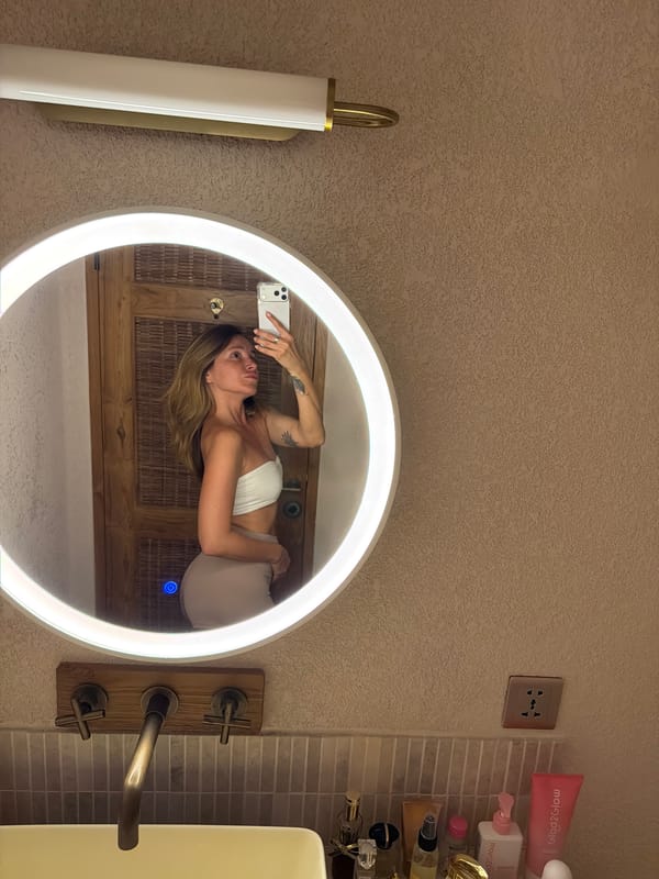 Woman takes mirror selfies in Mengwi bathroom area