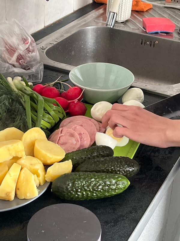Kitchen food prep documented with salad ingredients, anomalous artwork