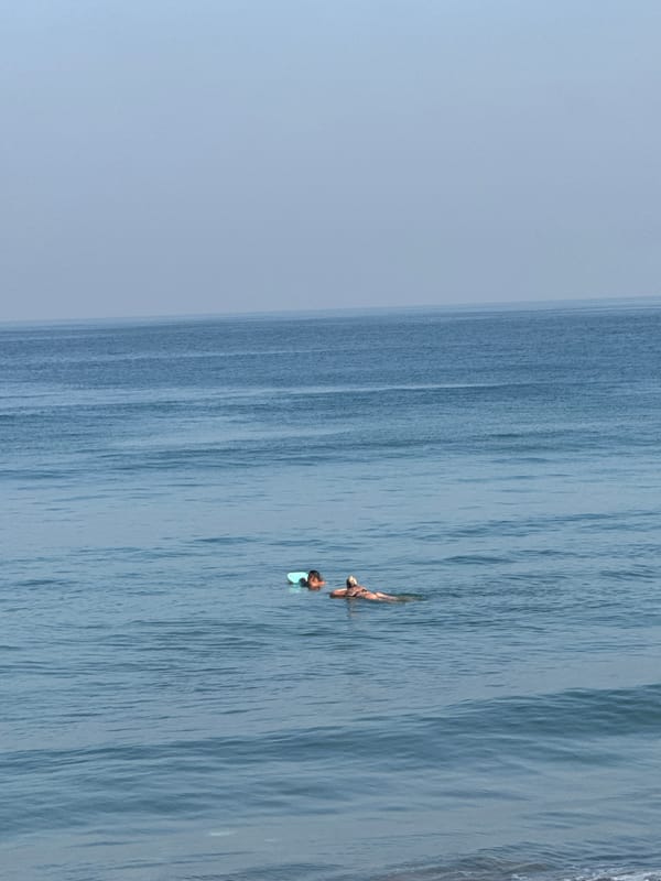 Surfers and swimmers out at Kuta Beach on a sunny afternoon