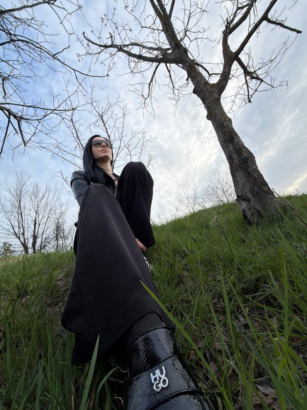 Person in black relaxes in grassy field in Pleven