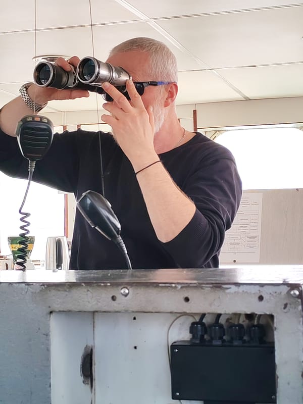 Man with binoculars observed near waterside church in Koprino