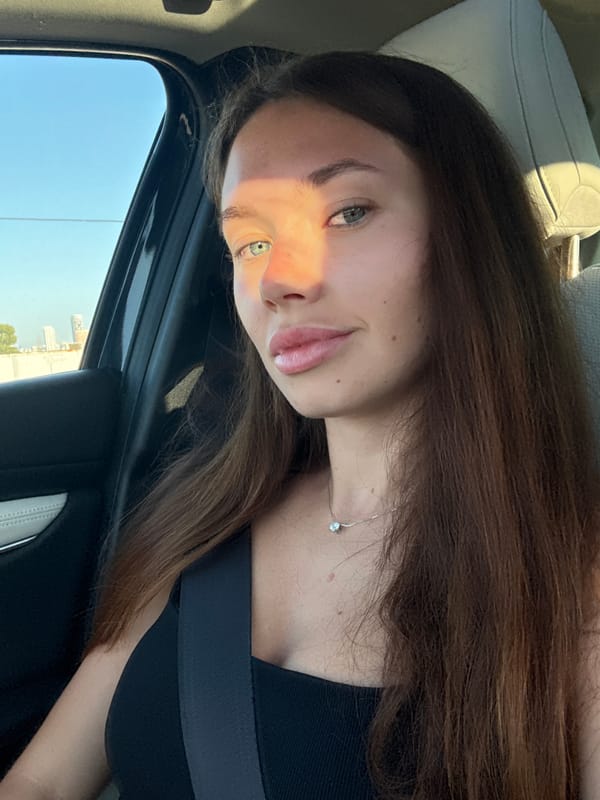 Woman photographed in car with Tel Aviv cityscape visible