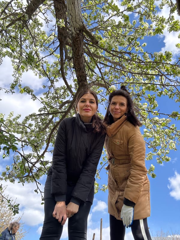 Women gather under blossoming tree in Dubovaya, Russia