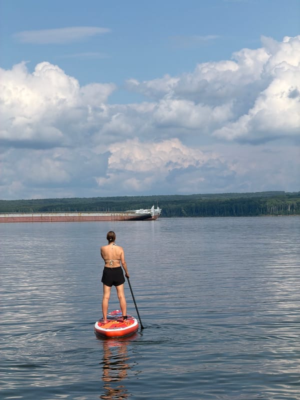 Paddleboarding on calm Russian river waters, summer morning